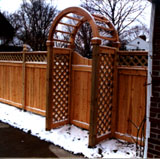 wood arbor with a gate and privacy fence by elyria fence